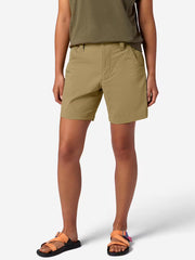 A person wearing tan cargo shorts on a white background