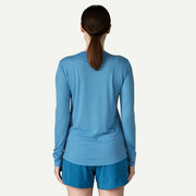A person from behind wearing a blue long sleeve shirt on a white background