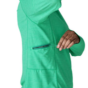 A person wearing a teal hoodie unzipping the side pocket on a white background