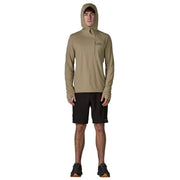 A person wearing a beige hoodie with the hood up on a white background