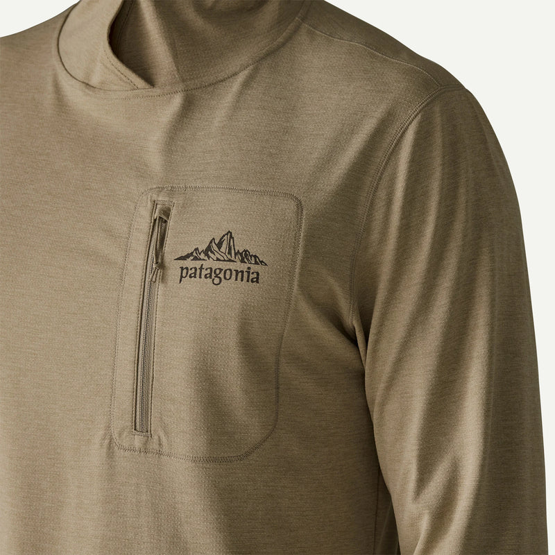 A close up on the front pocket on a beige hoodie on a white background