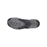 The outsole of a trail running shoe, showing a textured gray and black tread pattern with a small red triangular logo in the center.