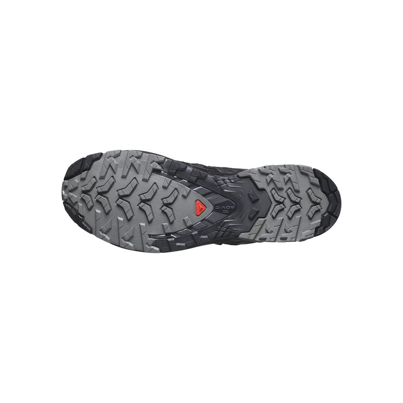 The outsole of a trail running shoe, showing a textured gray and black tread pattern with a small red triangular logo in the center.