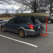 Car with a canoe on top in a parking lot