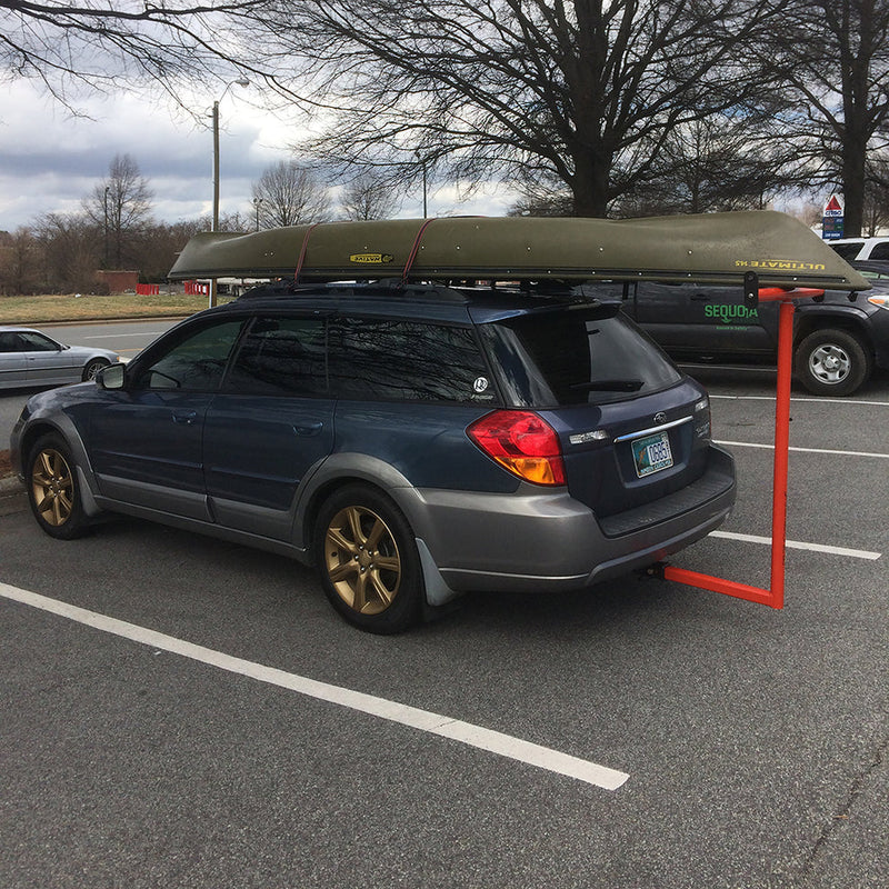 Car with a canoe on top in a parking lot