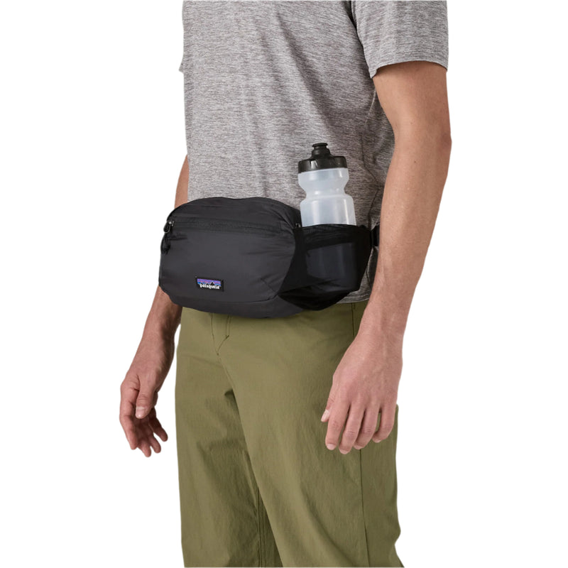 Person wearing a black waist bag with a water bottle on a white background