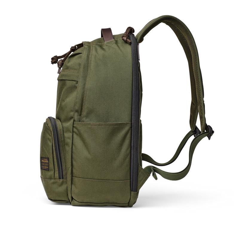 Side view of an olive colored backpack against a white background. 