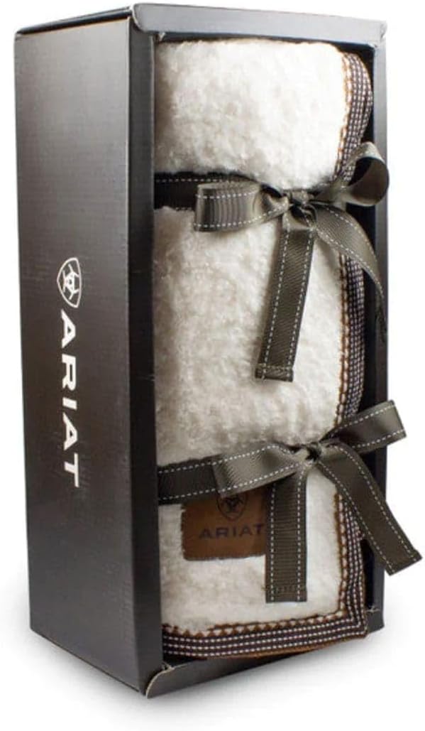 White fuzzy throw blanket wrapped in a ribbon in a display box against a white background. 