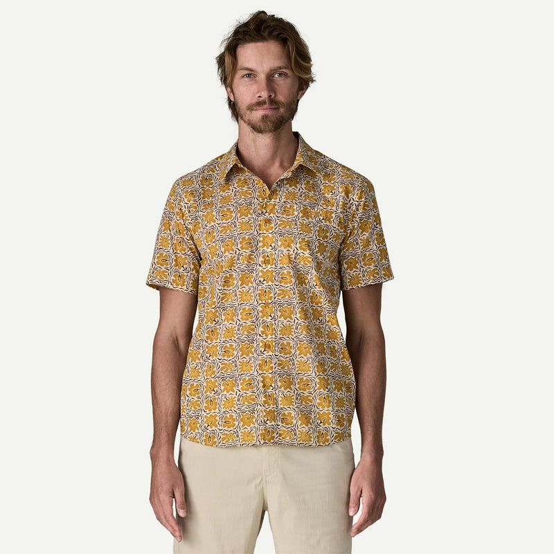 Man wearing a white and yellow patterned button down shirt on a white background.