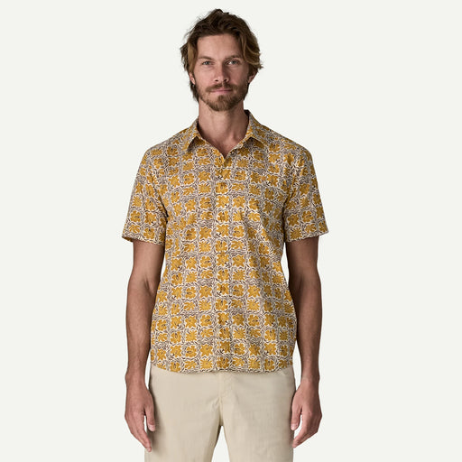 Man wearing a white and yellow patterned button down shirt on a white background.