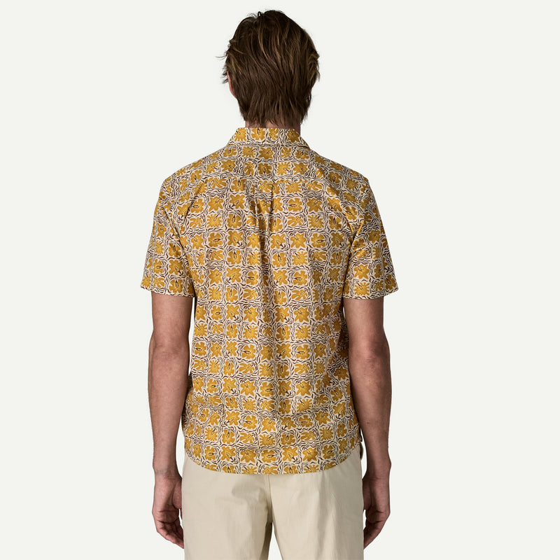Back view of a man wearing a white and yellow patterned shirt on a white background.