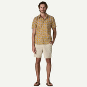 Man wearing a white and yellow patterned button down shirt on a white background.