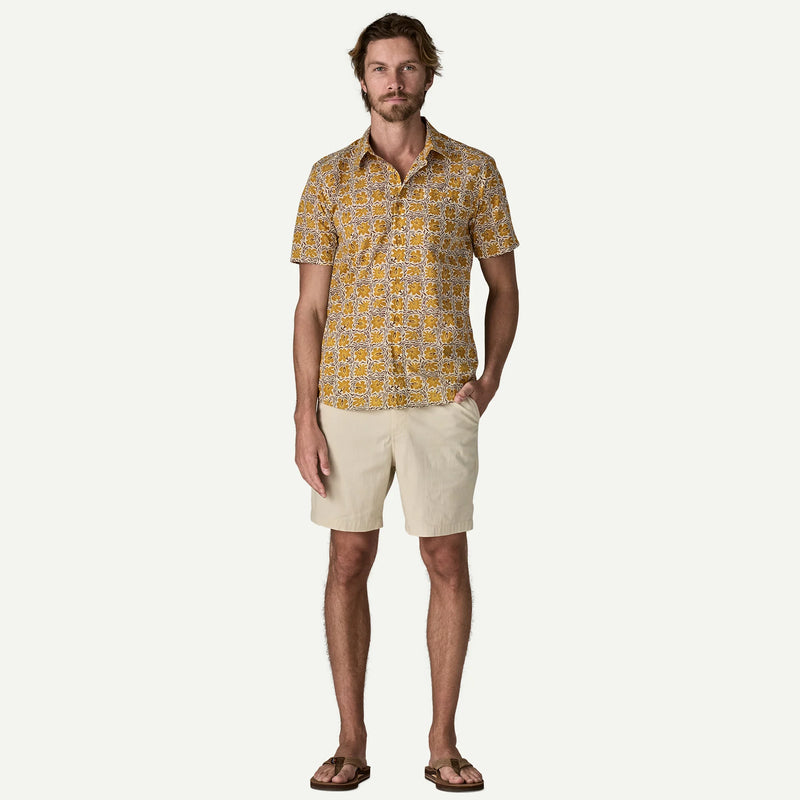 Man wearing a white and yellow patterned button down shirt on a white background.