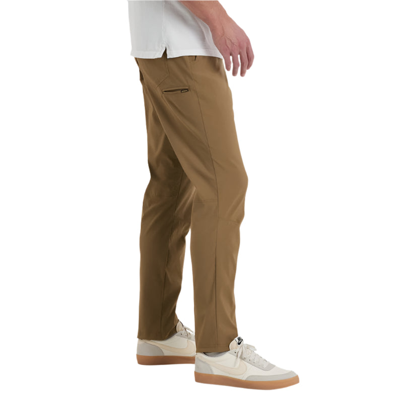 Person wearing brown pants and white sneakers on a white background