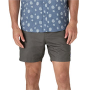 Person wearing a blue patterned shirt and gray shorts on a white background