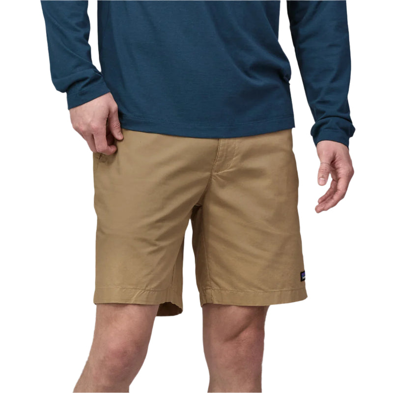 Person wearing beige shorts and a blue long-sleeve shirt on a white background