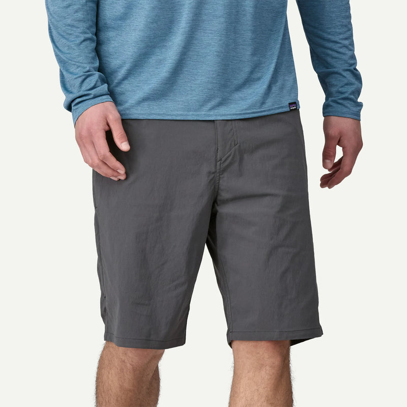 Person wearing gray shorts and a blue long-sleeve shirt on a light gray background
