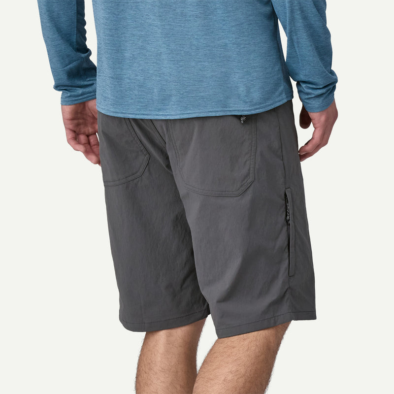 Person wearing gray shorts and a blue long-sleeve shirt on a white background