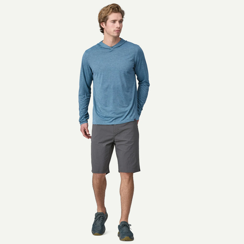 Man wearing a blue long-sleeve shirt and gray shorts on a white background