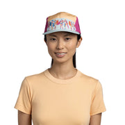 Woman wearing a colorful cap and peach shirt on a white background