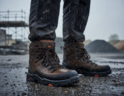 Brown hiking boot with orange accents on a white background