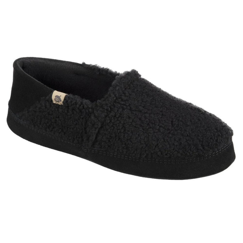 A fuzzy black slipper with a black bottom on a white background