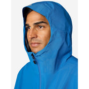 A man wearing a bright blue hooded rain jacket, shown in a close-up profile against a light gray background.