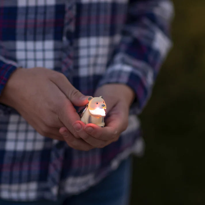 Person holding a mini bear-shaped flashlight.