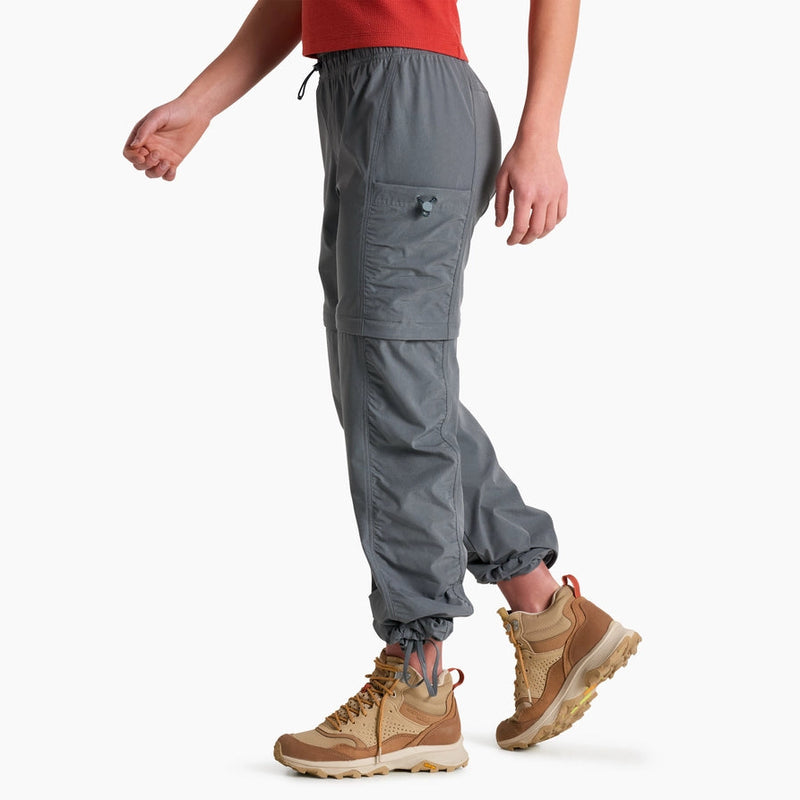 Person wearing gray cargo pants and tan boots on a white background