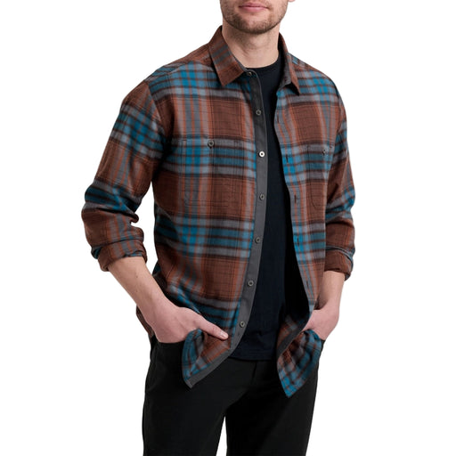 Man wearing a brown and blue plaid shirt on a white background