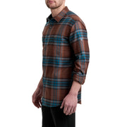 Person wearing a brown and blue plaid shirt on a white background