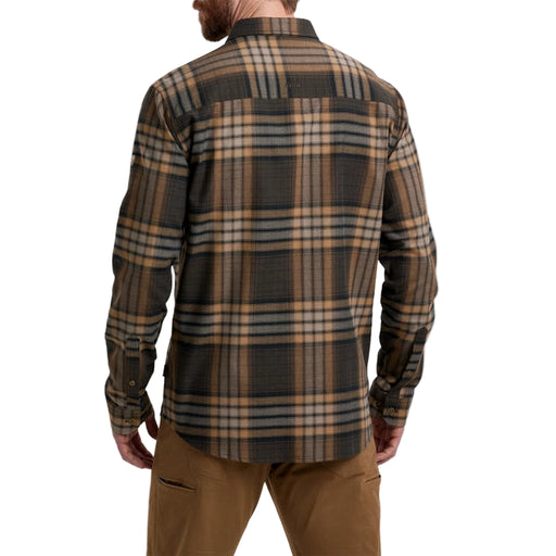 Man wearing a plaid shirt and brown pants on a white background