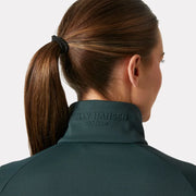 Person wearing a green jacket with 'Helly Hansen' branding on a light gray background