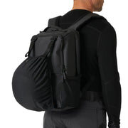 Person wearing a black backpack on a plain background