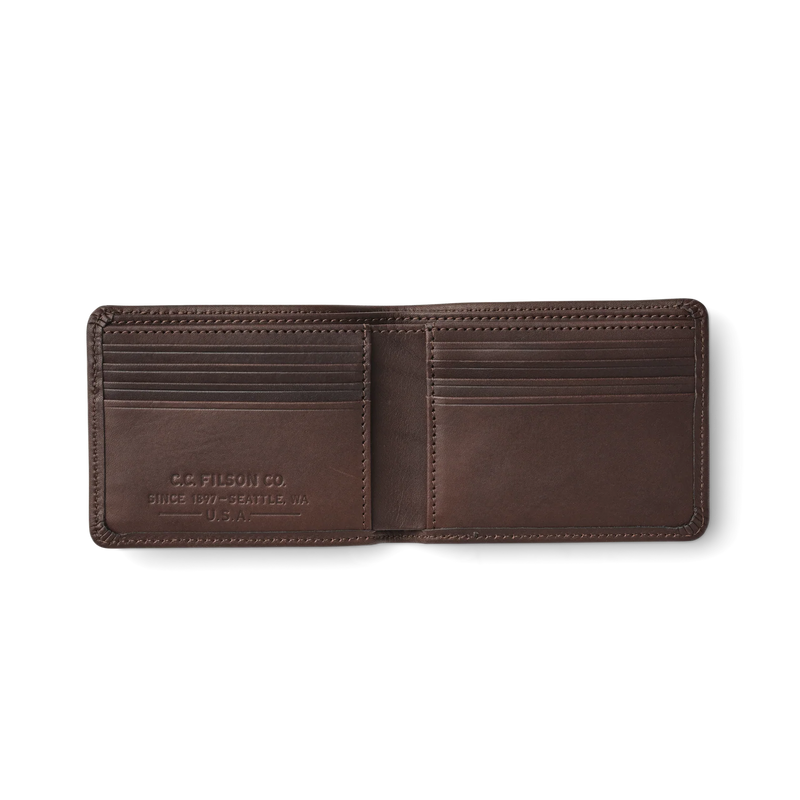 Opened up dark brown leather wallet against a white background. 