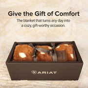 A blanket wrapped in a bow sitting in a gift box with a text above it that states "Give the gift of comfort".