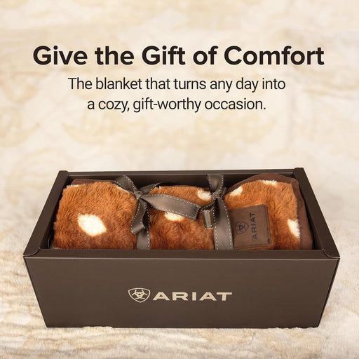 A blanket wrapped in a bow sitting in a gift box with a text above it that states "Give the gift of comfort".