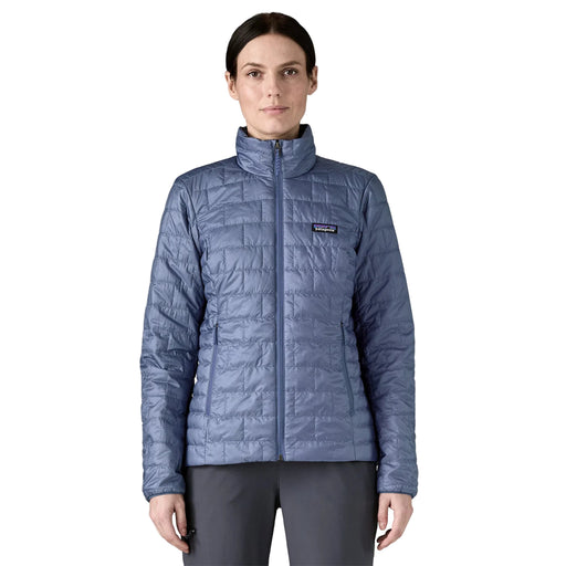 Person wearing a blue quilted jacket with a brand logo on a white background