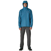 A person wearing a blue rain jacket with the hood up on a white background