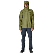 A person wearing a green rain jacket with the hood up on a white background
