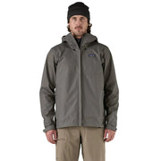 Man wearing a gray rain jacket with a brand logo on a white background