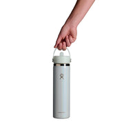 A hand holding the handle of a Hydro Flask insulated water bottle against a solid white background.