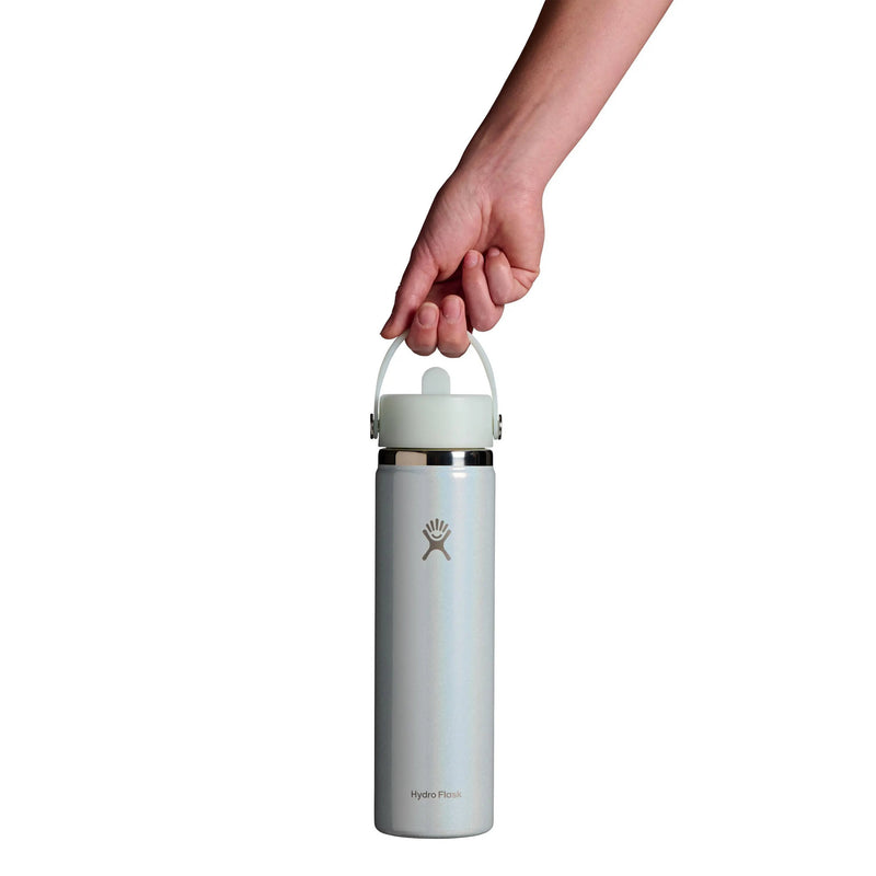 A hand holding the handle of a Hydro Flask insulated water bottle against a solid white background.