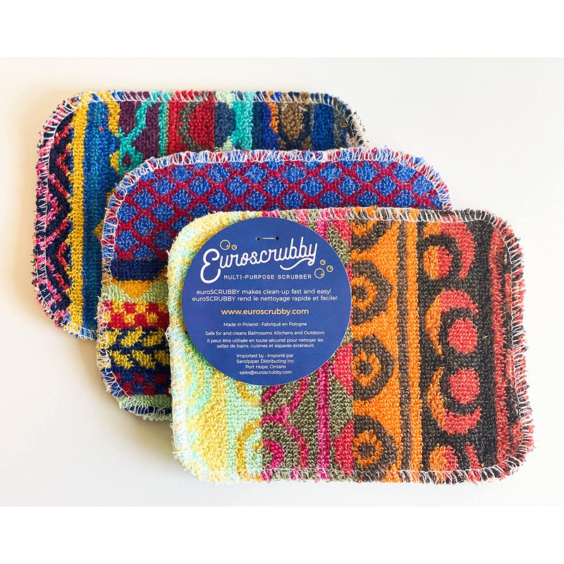Three Euroscrubby multi-purpose cleaning sponges with colorful geometric patterns, arranged in a fan shape with a blue brand label on top, on a white background.