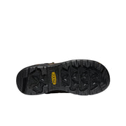 Bottom tread of a black work boot against a white background. 