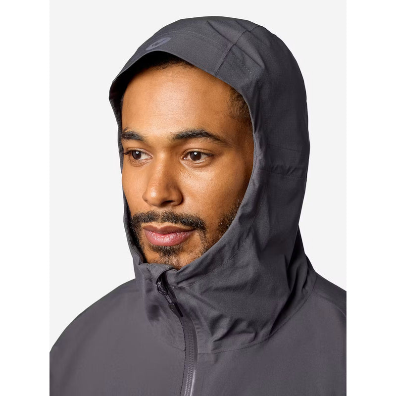 A man wearing a dark gray hooded rain jacket, shown from the chest up against a light gray background.