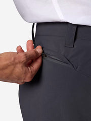 A person wearing navy blue cargo shorts unzipping the back pocket on a white background