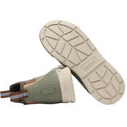 Green boot with beige sole on a white background