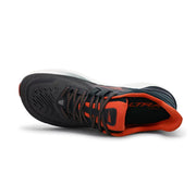 A black and red running shoe from above on a white background