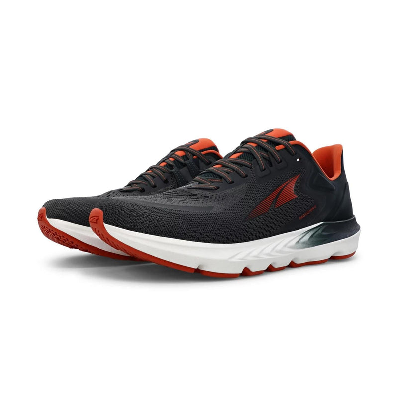 A pair of black and red running shoes with white bottoms on a white background